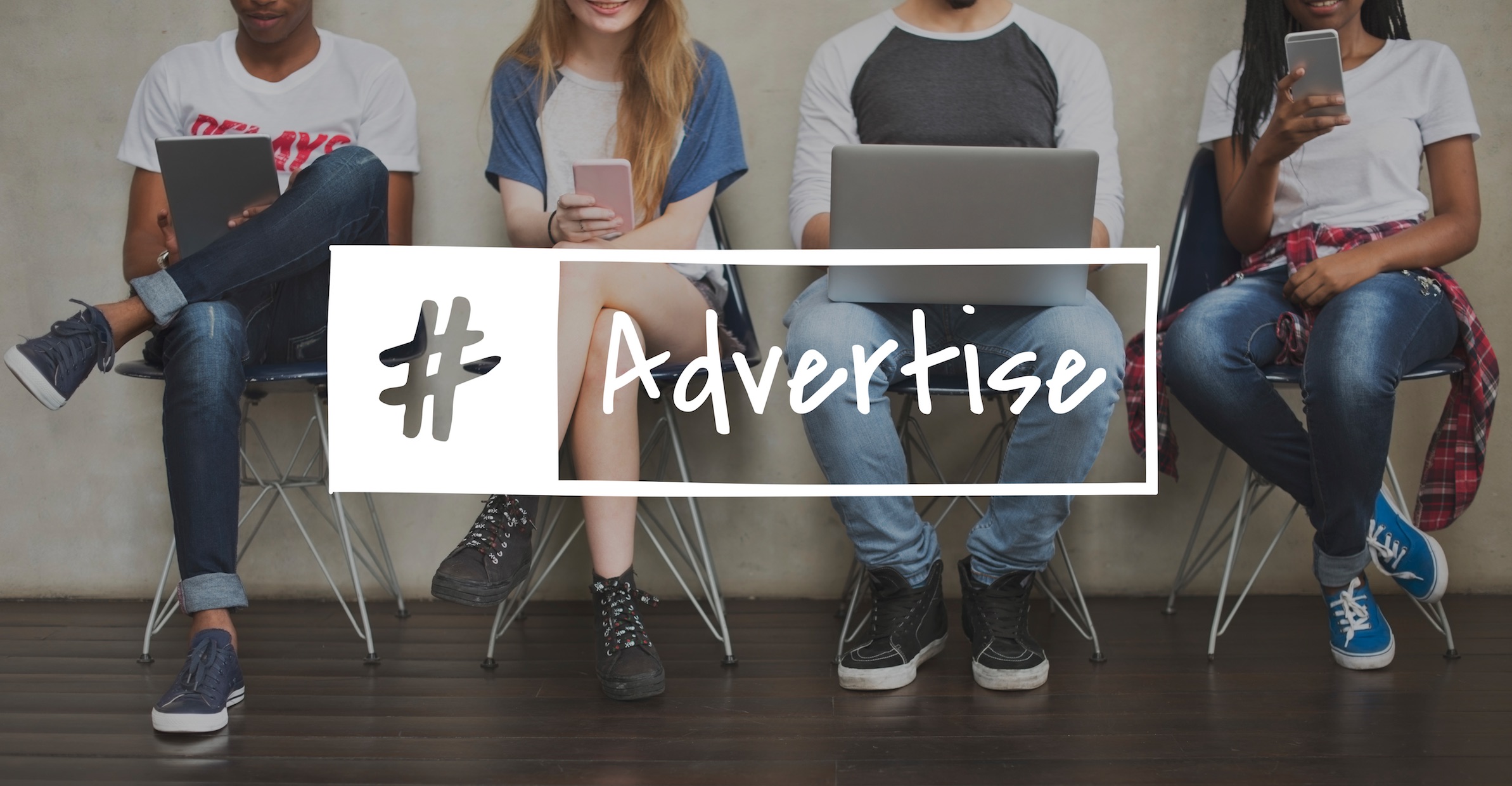 Young adults using laptops and phones; #Advertise. Marketing benefits of a website.